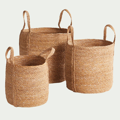 Set of three round woven natural fiber storage baskets with braided side handles.