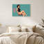 Femme en body noir assise sur un tabouret, toile murale sur fond turquoise-795538829
