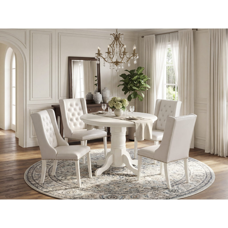 L'ensemble de table de cuisine 5 pièces pour 4 personnes comprend une table de salle à manger ronde avec piédestal et 4 chaises rembourrées en tissu crème, noir