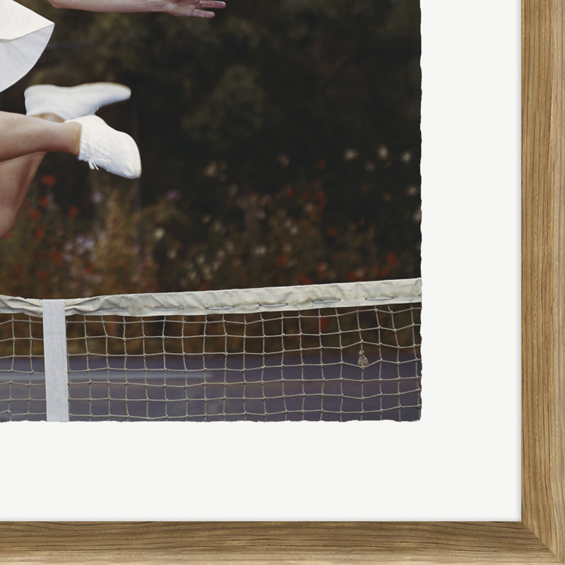 Couple On Tennis Court, Woman Jumping In Foreground Giclee Print by Getty Images