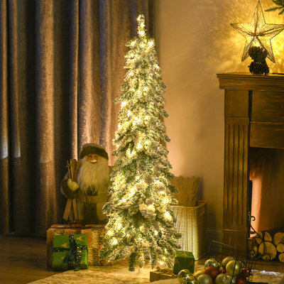 Grand haut sapin de Noël artificiel avec des branches enneigées, forme de Downswept