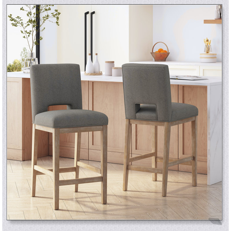 Tabourets de bar modernes et rembourrés avec des pieds en bois robustes, parfaits pour les cuisines et les salles à manger contemporaines.