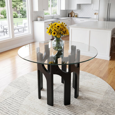 Table de salle à manger ronde de style moderne du milieu du siècle, en verre trempé de 117 cm (46 po), avec un piètement sculptural arqué en MDF à grain de bois.