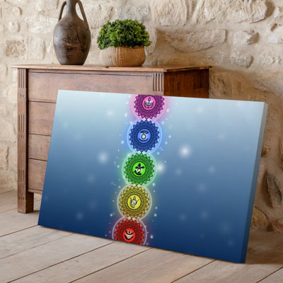 La toile crée un arrangement vertical de sept symboles chakra complexes, chaque art mural inclus dans un mandala floral décoratif avec un art mural sur toile