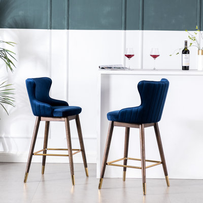Ensemble de 2 tabourets de bar capitonnés bleus à dossier enveloppant - Rembourrage en mousse haute densité, design vintage, pieds en hévéa massif finition noyer, revêtement en tissu effet velours, assise de 39 cm de profondeur x 47 cm de largeur, 5 cm d'épaisseur, forme effilée élégante
