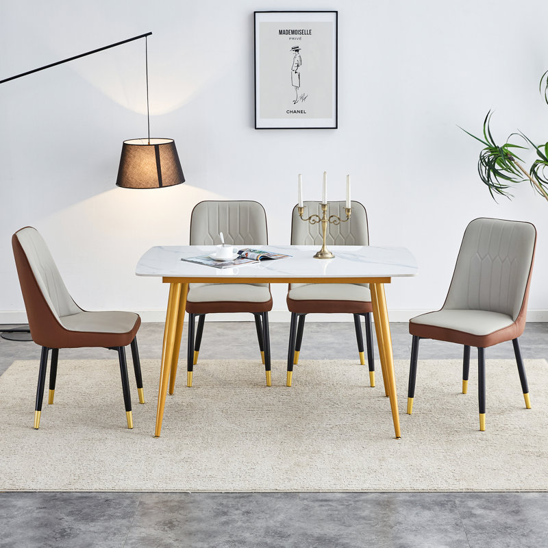 Ensemble de table et de chaises: table moderne avec plateau en imitation marbre blanc et pieds en métal doré, jumelée à 4 chaises en cuir synthétique