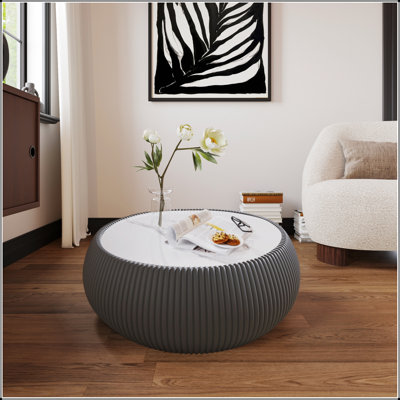 Table basse en forme de tambour en bois fritté avec motifs uniques et base en cuir, parfaite pour les salons modernes