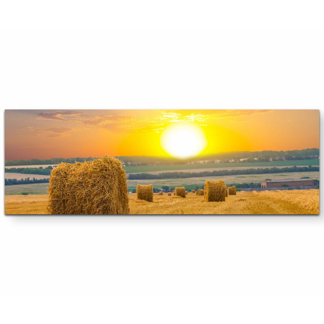 Leinwandbild Feld mit Strohballen und Sonnenuntergang