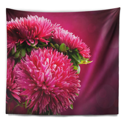 Fleurs roses d'asters sur une tapisserie rouge