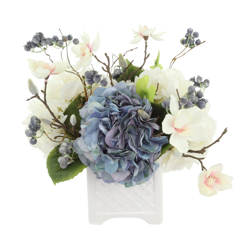 Hortensia, berris et magnolia disposés dans un pot en céramique