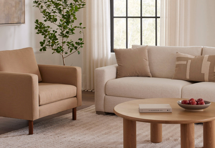 Living room setup with chair, sofa, and The Kinfolk Home book on the table.