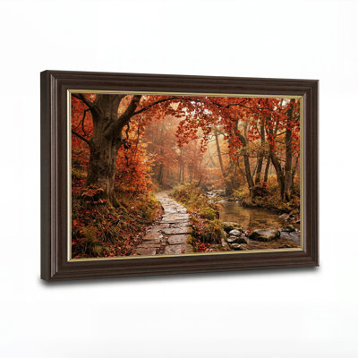 Tableau sur toile représentant un chemin de pierres au bord d'un ruisseau, dans une forêt d'automne orange