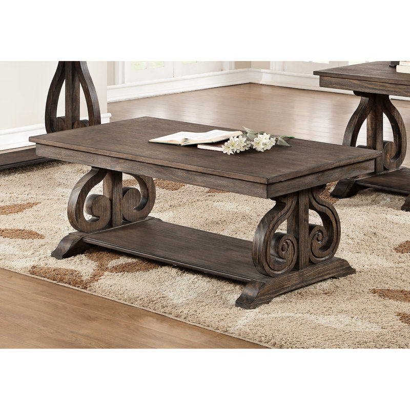 Table de salon en chêne foncé avec base à volutes et tablette pratique