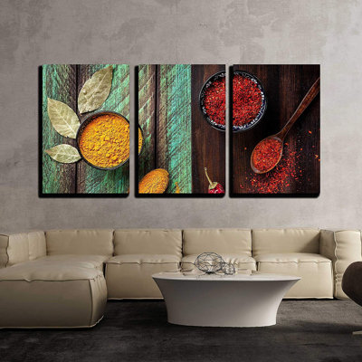 Chili, paprika, curcuma et feuilles de laurier sur fond vert et brun en bois, décoration murale moderne