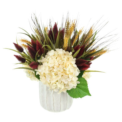 Composition automnale d'hortensias et de chardons dans un pot en céramique
