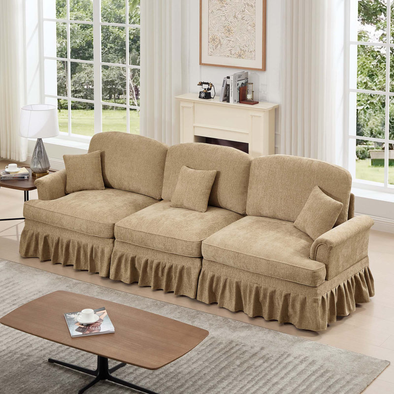 Élégant canapé trois places Mid-Century avec accoudoirs évasés, jupes amovibles et pieds fuselés, idéal pour le confort du salon