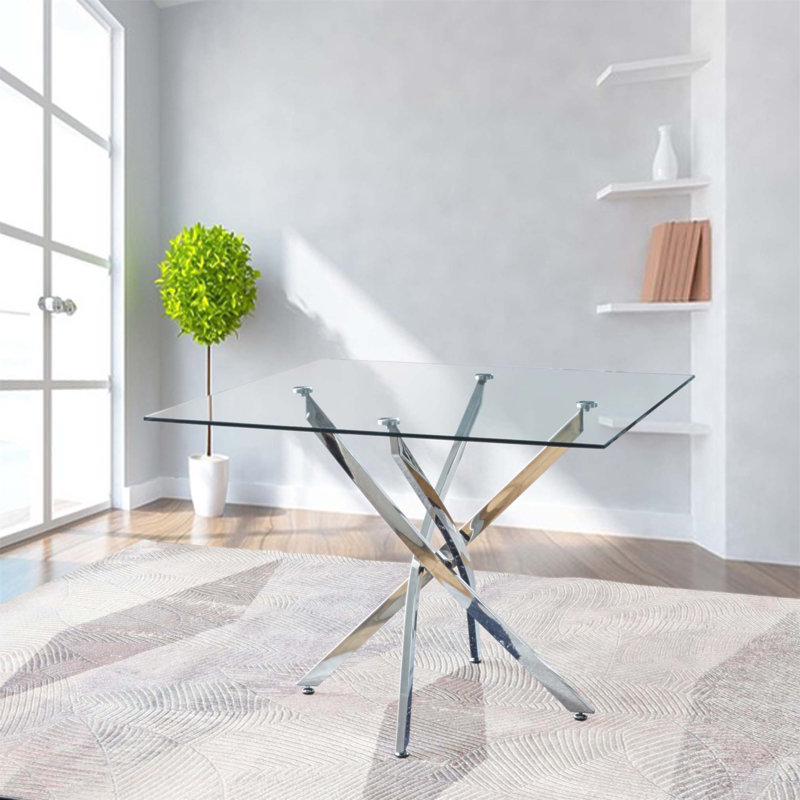 Table carrée contemporaine en verre trempé transparent avec pieds élégants en acier inoxydable à finition argentée, parfaite pour les intérieurs modernes et les espaces compacts.