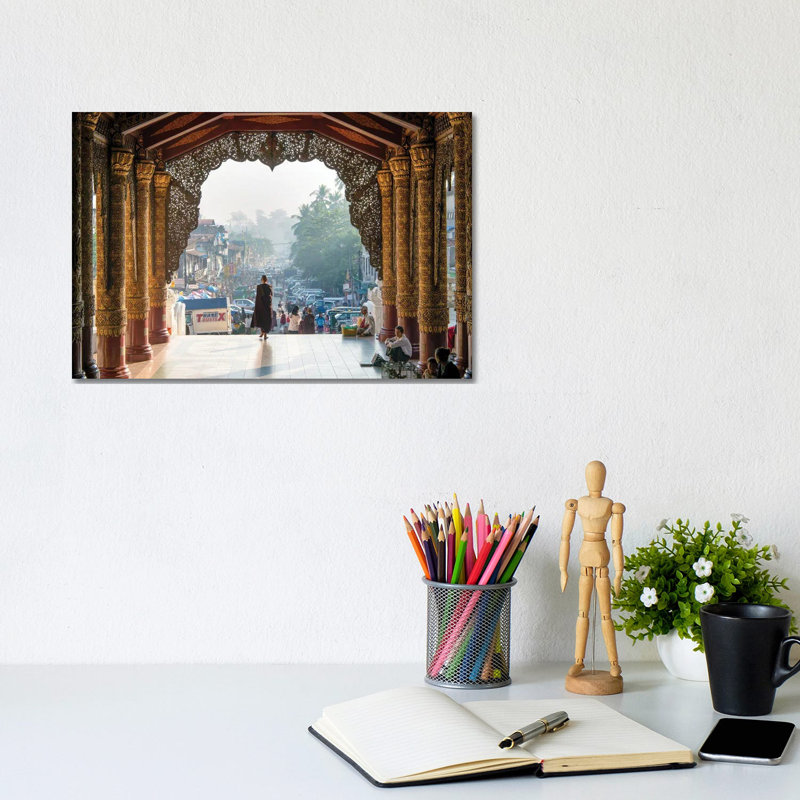 Buddhist Monk Passing The Entrance Of The Shwedagon Pagoda In Yangon, Myanmar by Jan Becke - Wrapped Canvas Print