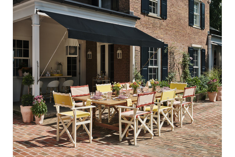 garden party ideas with an outdoor dining set wooden table and canvas chairs with the table set with floral centerpieces and matching dinnerware