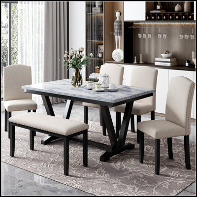 Table de salle à manger moderne en pierre artificielle avec bord incurvé et pieds en métal gris foncé, pouvant accueillir six personnes pour des repas élégants