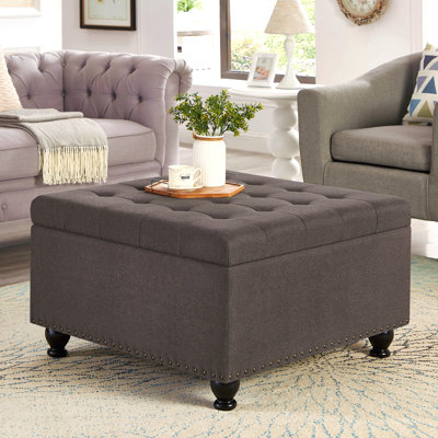 Grand repose-pieds carré avec rangement et pieds en bois, table basse capitonnée avec garniture cloutée pour espace de vie, gris foncé