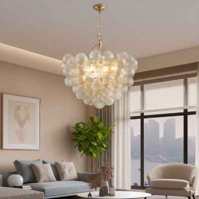 Luminaire suspendu avec une finition dorée et des abat-jours sphériques en verre transparent avec une texture filetée de 23,6 pouces de diamètre, offrant une longueur de suspension réglable pour une installation au-dessus des cuisines, des salles à manger et des espaces de vie (ampoules non incluses).