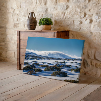 Canvas A Serene Winter Landscape Featuring Expansive Undulating Snow Covered Hills Wall Art Under A Clear Blue Sky In The Background A Canvas Wall Art