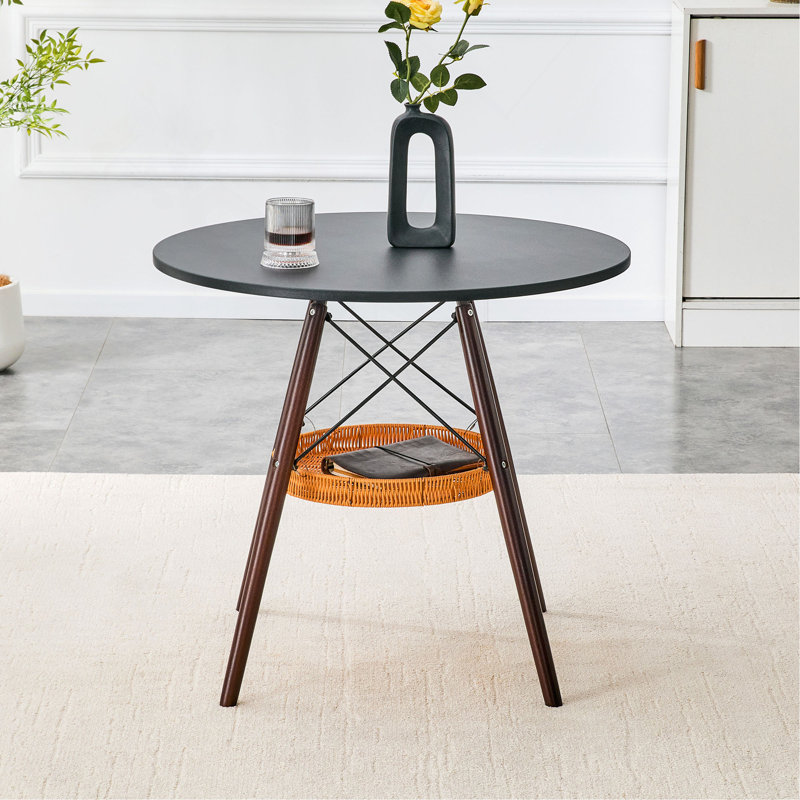 Table de salle à manger circulaire de 31,5 pouces de diamètre, plateau de table en panneau de fibres à densité moyenne noir, pieds en bois massif de noyer, avec structure de panier de rangement tissé suspendu. Une table basse décontractée pouvant accueillir de 2 à 4 personnes.