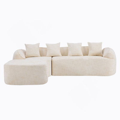 Canapé en forme de L beige en chenille qui s'agence bien avec n'importe quel salon. Il est doté d'une éponge hautement élastique pour une sensation d'assise confortable, d'accoudoirs courbés et de quatre coussins décoratifs.