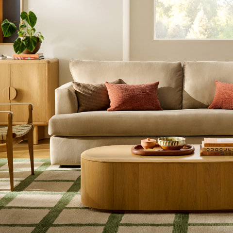 Living room with beige sofa and light wood coffee table.