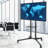 Aivils Black Adjustability Multi Screen Floor Stand Mount for Greater Than 50" with Shelving, Holds up to 50 kg.