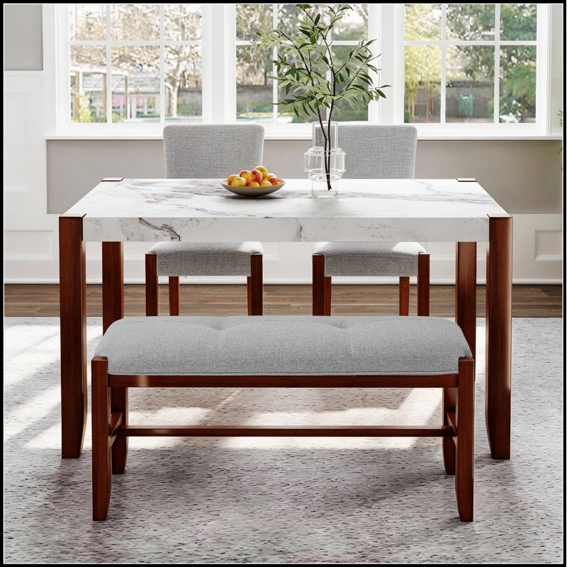 Ensemble de salle à manger moderne quatre pièces comprenant une table d'aspect marbre, des chaises rembourrées et un banc avec pieds en bois massif.