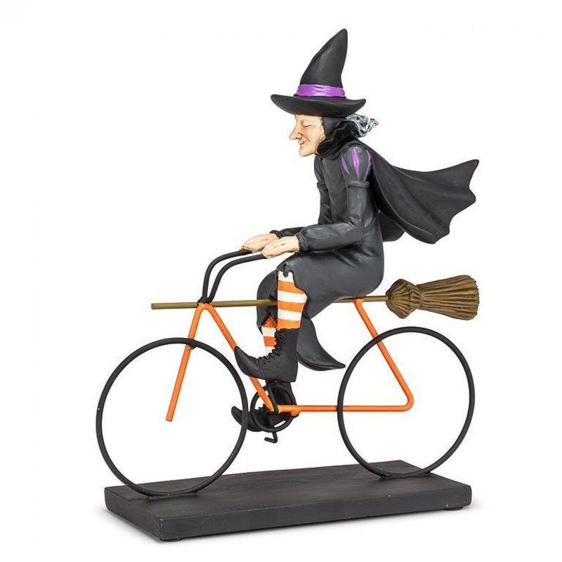 Figurine de sorcière chevauchant un vélo