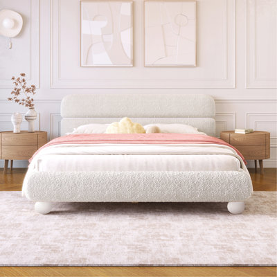 Lit tapissier contemporain avec tissu bouclé en molleton et pieds ronds massifs, design courbé élégant pour la chambre à coucher