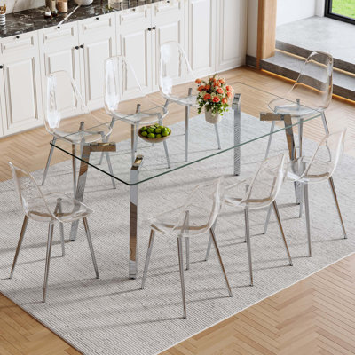 Ensemble de table et de chaises. Table de salle à manger rectangulaire de 71 x 35,4 pouces. Plateau de table en verre trempé, 7 pieds de table en métal. Assorti d'une chaise de salle à manger en plastique transparent avec pieds en métal.