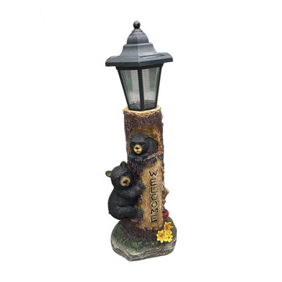 A brown bear statue welcoming guests, a garden statue with solar-powered lights, a 19-inch resin bear family in a tree, and outdoor bear decorations for courtyards, gardens, lawns, and patios.
