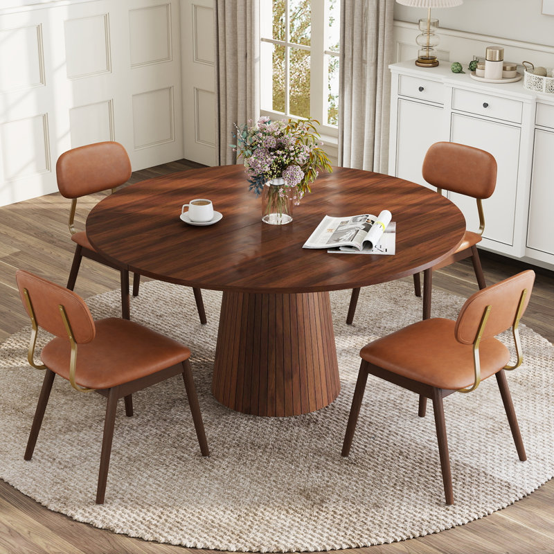 Ensemble de table et chaises de salle à manger rondes modernes de 119 cm (47 po) pour 4 à 6 personnes, avec pied central et chaises rembourrées.