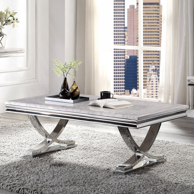 Table basse moderne de style glamour avec plateau en faux marbre et base piédestal chromée, parfaite pour les espaces de vie luxueux.