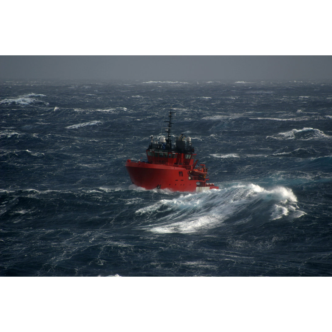 Rotes Boot auf dem Meer während eines Sturms