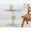 Élégante table d'appoint dorée avec motif à nœuds de corde et base en marbre blanc, parfaite pour les intérieurs modernes et classiques.