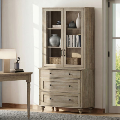 Bibliothèque Corretta à 3 niveaux (183 cm H x 86 cm L) avec portes vitrées et 3 tiroirs, style ferme, en bois, idéale pour le salon, le bureau ou la cuisine. Couleur : gris délavé.