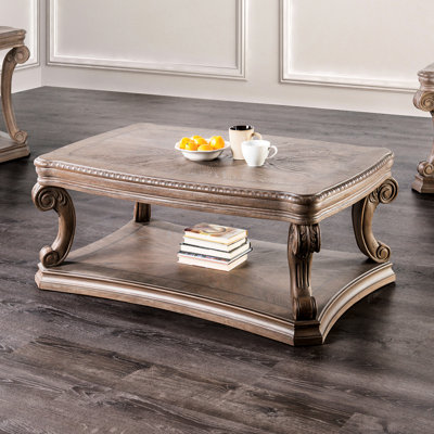 Table basse traditionnelle avec pieds à volutes, moulures en dentil et tablette ouverte, finition chêne pour le décor du salon