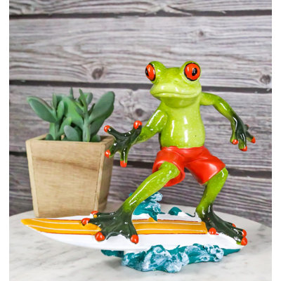 Figurine de surfeur crapaud en short chevauchant des vagues de l'océan avec planche de surf