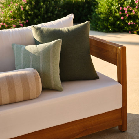 Outdoor couch with pillows in green and beige.