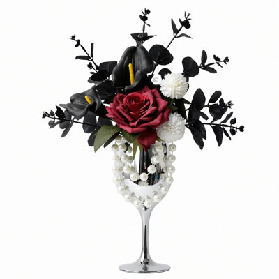 Composition florale artificielle rouge et noire, composée de roses rouge foncé, de callas noirs et d'eucalyptus noir, avec vase en forme de gobelet argenté et décorations de perles. Décoration de table idéale pour un mariage, une fête ou toute autre occasion.