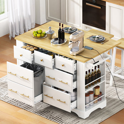 Îlot de cuisine polyvalent avec 6 tiroirs, une poubelle coulissante, un comptoir rabattable, des prises de courant intégrées et 5 roulettes verrouillables pour une cuisson et un rangement flexibles.