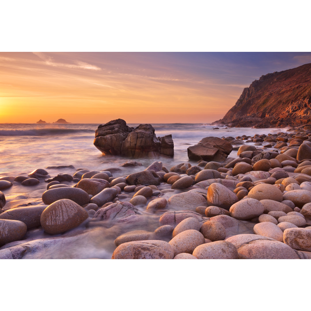 Felsiger Strand bei Sonnenuntergang - Leinwandbild