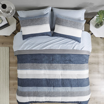 Édredon simple à rayures avec draps en bleu et gris. Rembourrage. Édredon, taies décoratives, drap plat, taies d'oreiller ajustées. Convient à un matelas de 14 po ou moins. Lavable à la machine. Draps bleu / gris modernes.