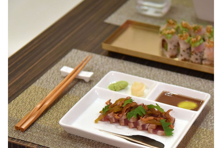a plate of sushi with a set of chopsticks next to it