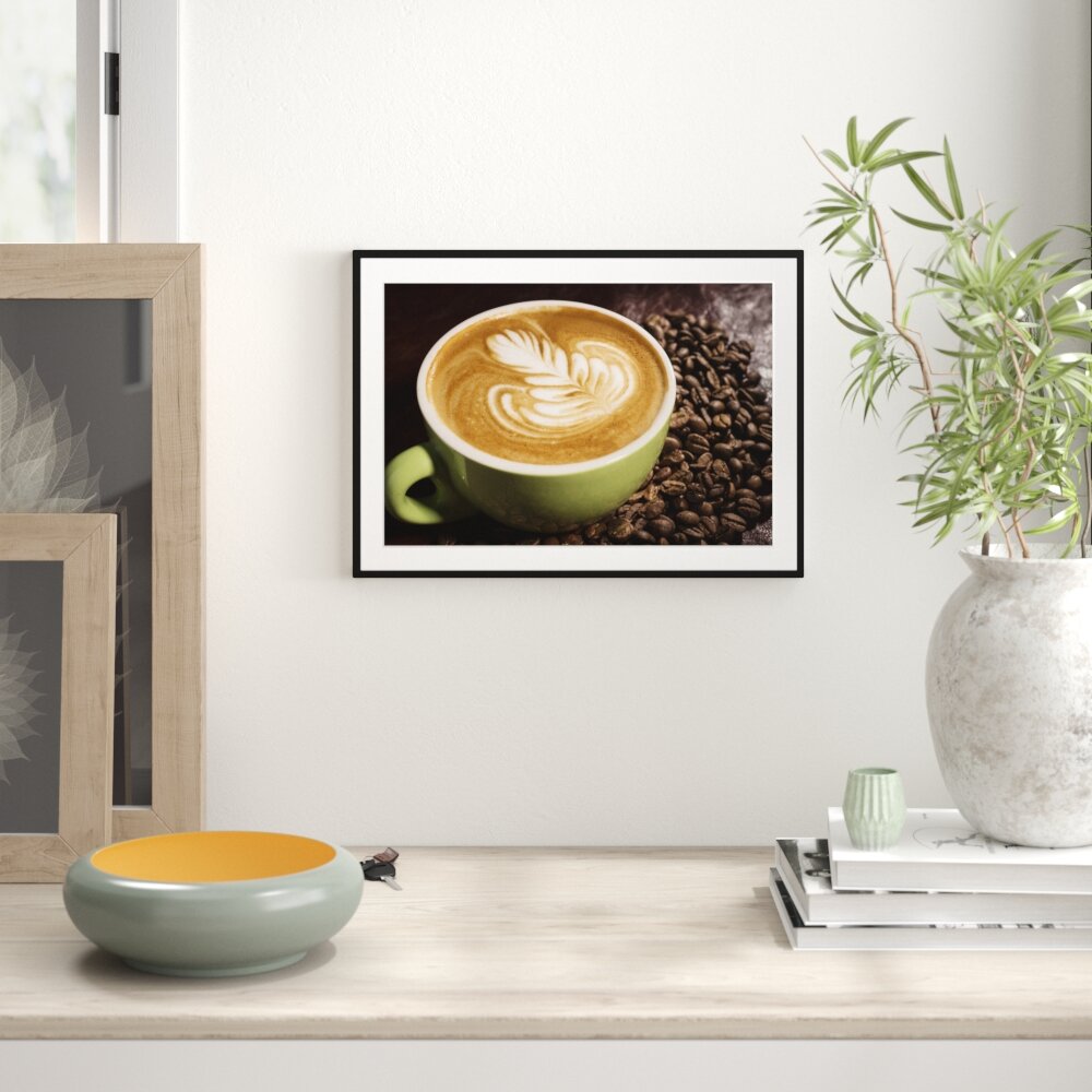 Gerahmtes Poster Cappucino zwischen Kaffeebohnen